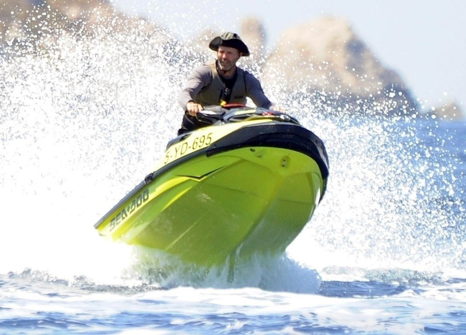 <p>Jason Statham catches a wave while in the water off the coast of Formentera, Spain, on Aug. 9.</p>