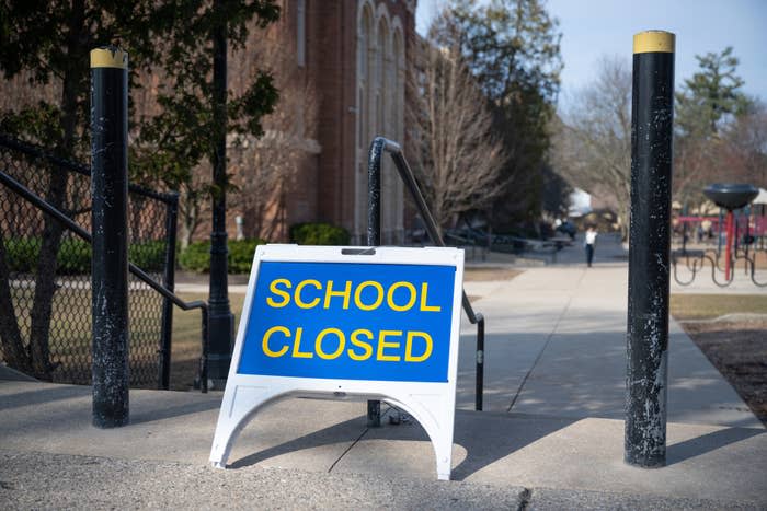 Sign reading "SCHOOL CLOSED" in front of a building, indicating a temporary closure