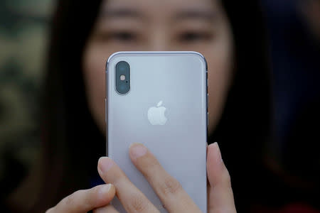 FILE PHOTO: An attendee uses a new iPhone X during a presentation for the media in Beijing, China October 31, 2017. REUTERS/Thomas Peter/File Photo