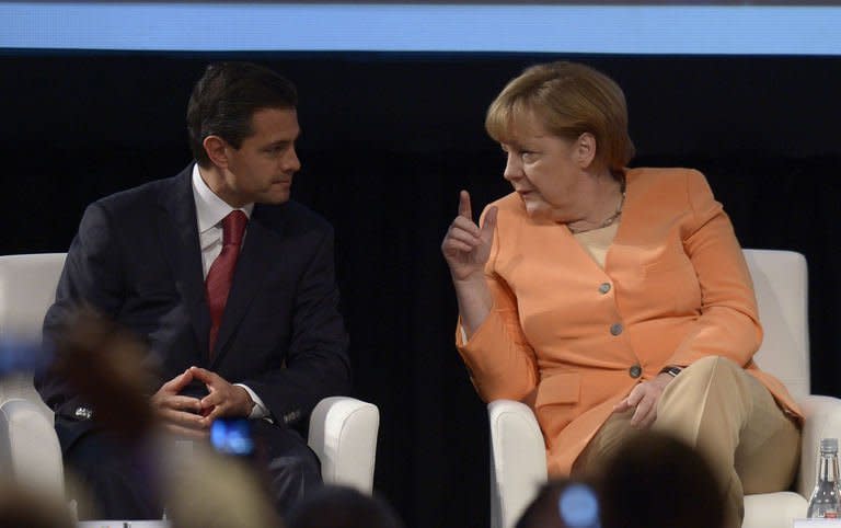 Mexican President Enrique Pena Nieto (L) and German Chancellor Angela Merkel chat during the Business Meeting being held in Santiago on January 26, 2013. Leaders of crisis-hit Europe are meeting their counterparts from resource-rich Latin America in Santiago Saturday to press for closer trade ties to spur global growth