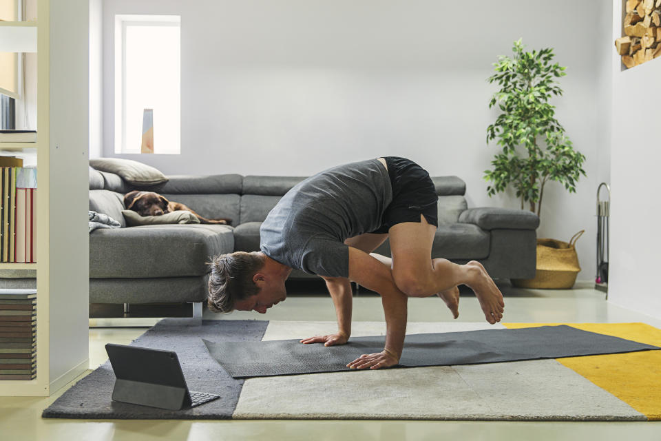 Man doing yoga at home on mat. (Getty Images)