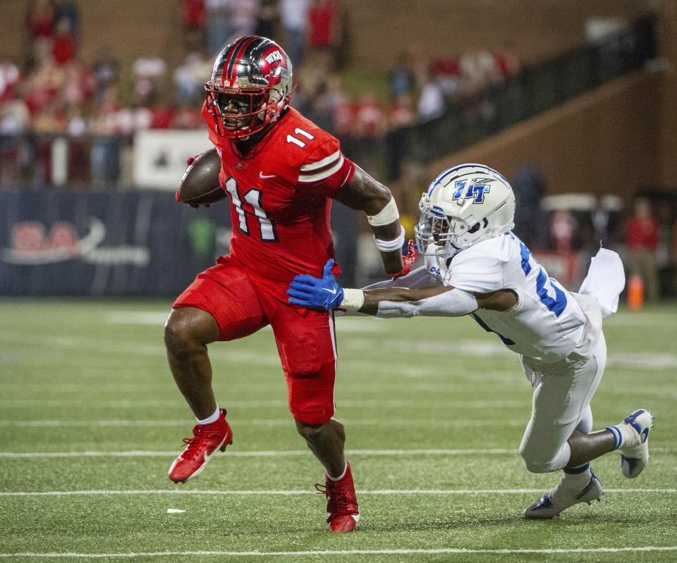 Western Kentucky wide receiver Malachi Corley (11) breaks a tackle by Middle Tennessee State linebacker Parker Hughes (21) during the first half of an NCAA college football game Thursday, Sept. 28, 2023, in Bowling Green, Ky. (Joe Imel/Daily News via AP)