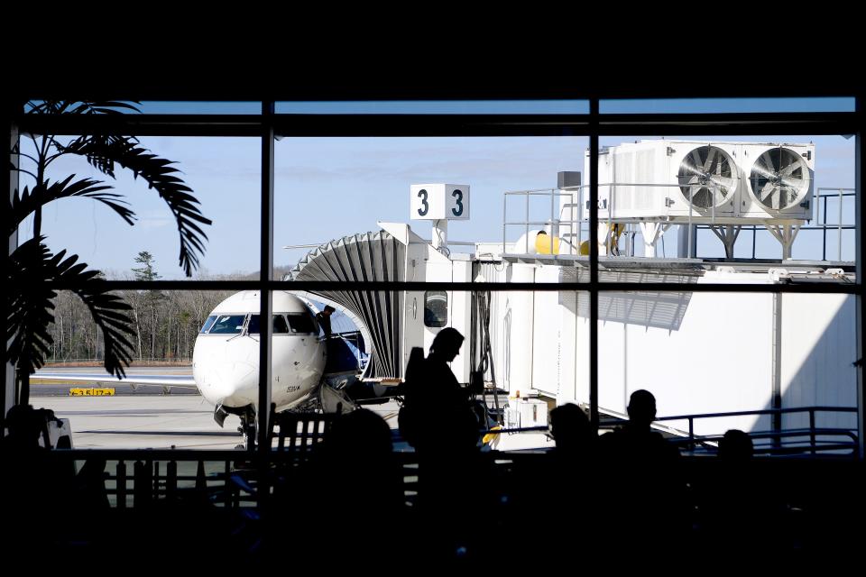 Travelers wait for their flights at the gate as passengers disembark from a plane at the Asheville Regional Airport in this Citizen Times file photo.
