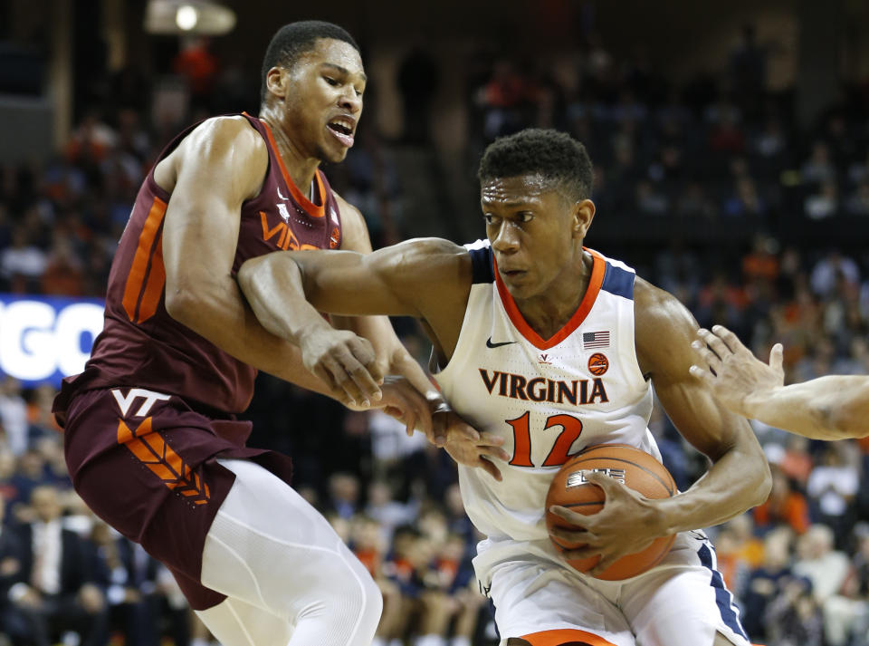 Virginia Tech forward Kerry Blackshear Jr. , left, tries to block Virginia guard De'Andre Hunter (12) during the first half of an NCAA college basketball game in Charlottesville, Va., Tuesday, Jan. 15, 2019. (AP Photo/Steve Helber)