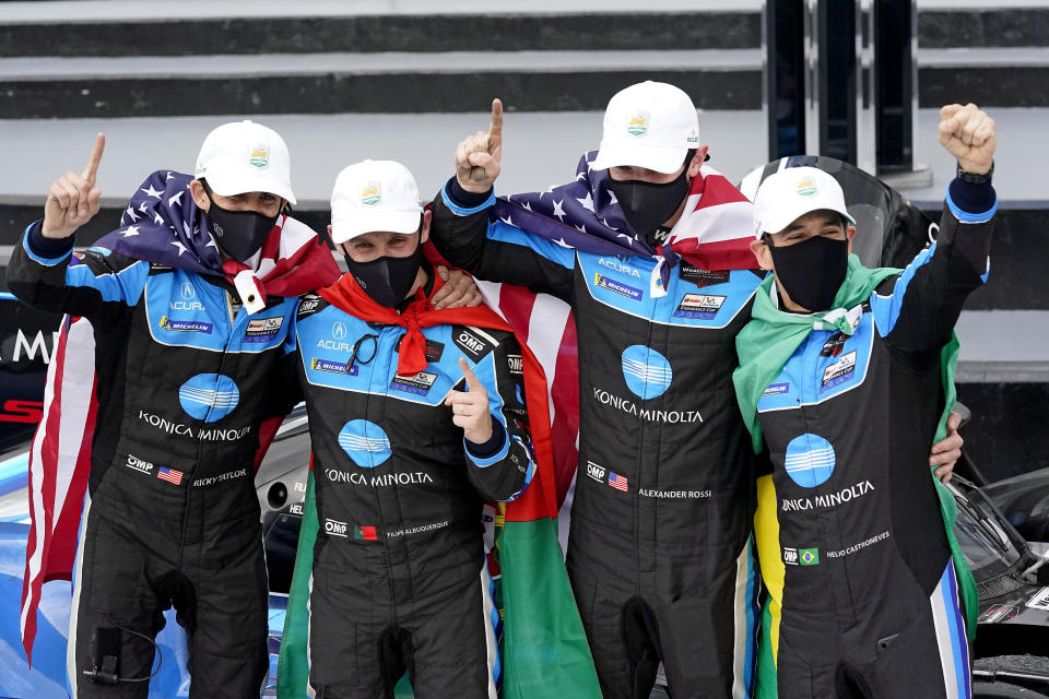 The Konica Minolta racing team, from left to right, Ricky Taylor, Filipe Albuquerque, Alexander Rossi and Helio Castroneves celebrate in Victory Lane after winning the Rolex 24 hour auto race at Daytona International Speedway, Sunday, Jan. 31, 2021, in Daytona Beach, Fla. (AP Photo/John Raoux)