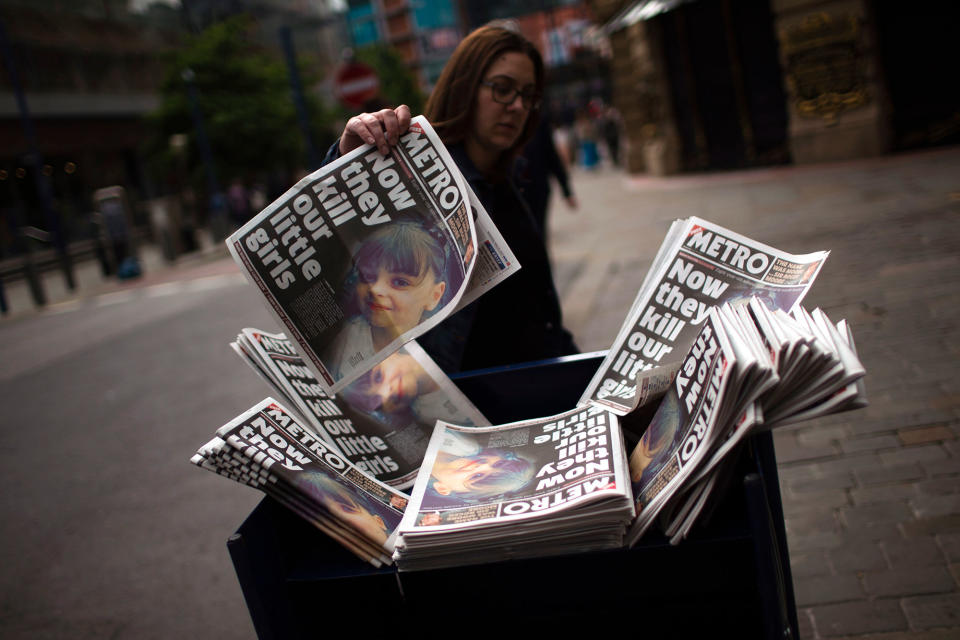 <p>A woman picks a newspaper reporting the news on the suicide attack at a concert by Ariana Grande that killed more than 20 people as it ended Monday night in central Manchester, Britain, Wednesday, May 24, 2017. (AP Photo/Emilio Morenatti) </p>