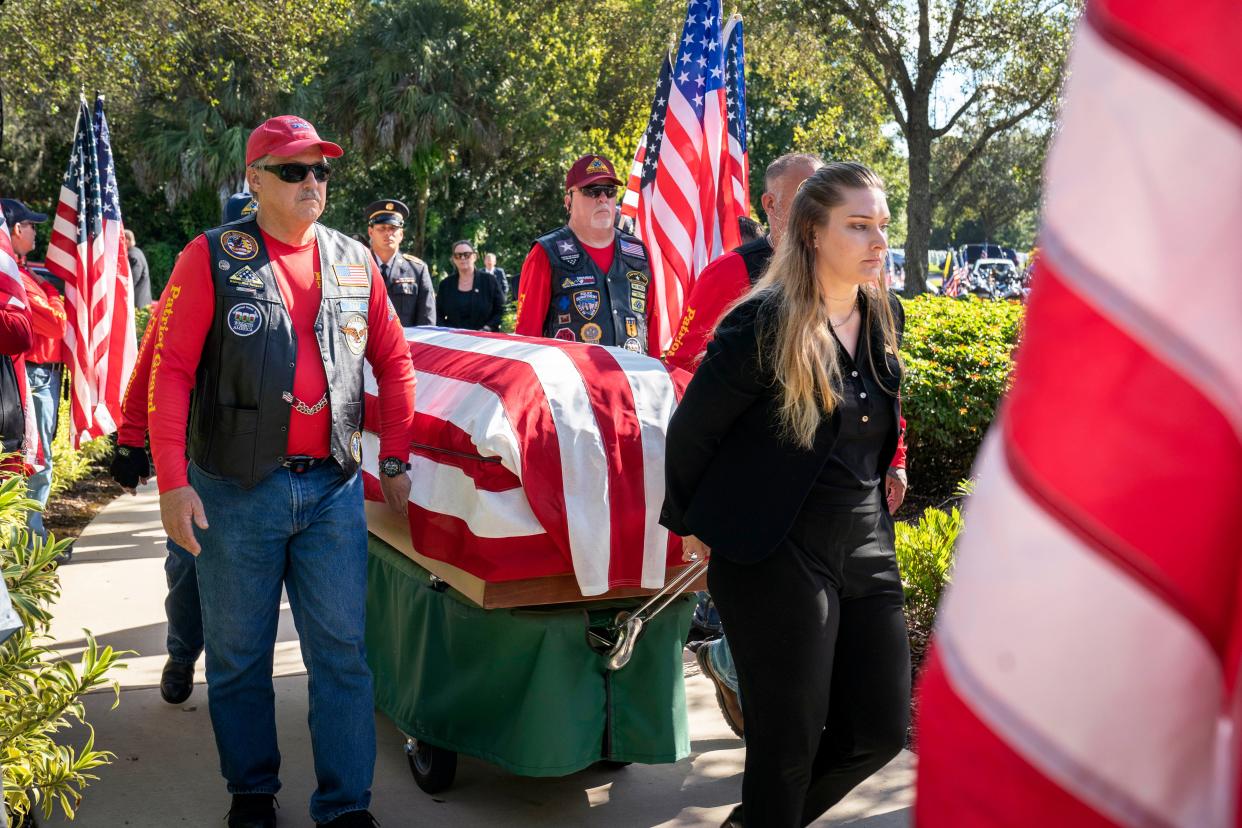 Boynton Memorial Chapel funeral director Hannah Weiss and Patriot Guard Riders move the casket of Army Pfc. Roy J. Searle, who was killed in December 1944 during battle in Germany.