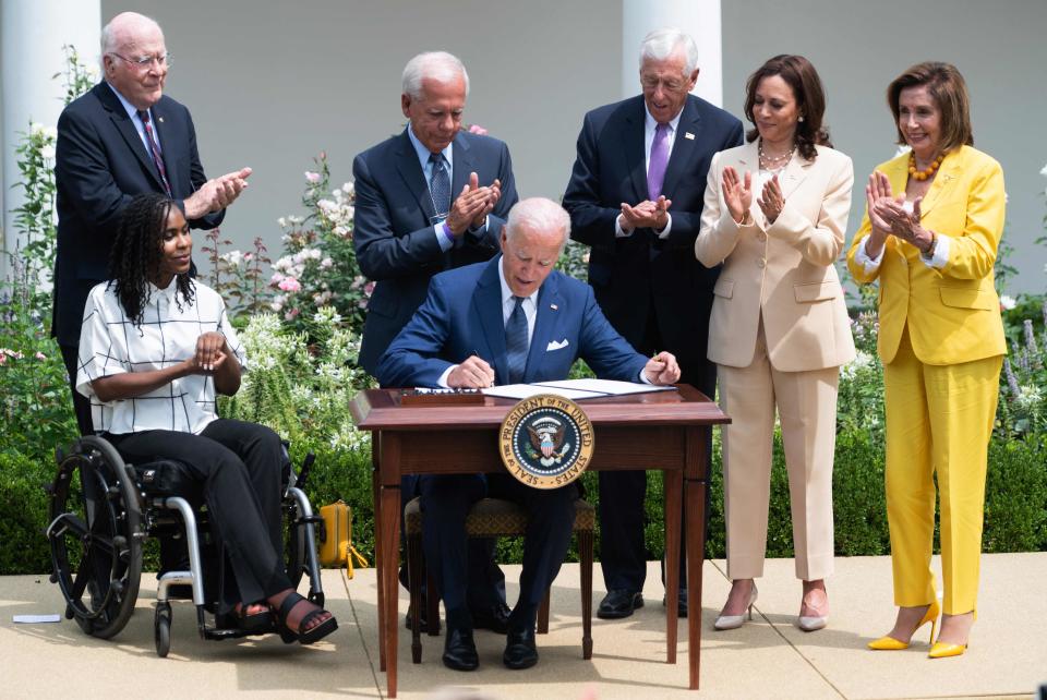 President Joe Biden signs a proclamation to commemorate the 31st anniversary of the Americans with Disabilities Act, alongside artist Tyree Brown, left, Sen. Patrick Leahy, D-Vt., former Rep. Tony Coelho, D-Calif., House Majority Leader Steny Hoyer, D-Md., Vice President Kamala Harris and Speaker of the House Nancy Pelosi during a ceremony in the Rose Garden of the White House in Washington on July 26, 2021.