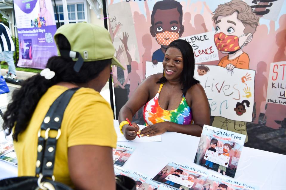 "I know a lot of our kids have questions about things that they have seen as far as George Floyd, Breonna Taylor, and things of that nature. I wrote a book on a child-friendly level to help explain what they have been seeing or have witnessed," said local author Bri Coleman (middle), who signs a copy of her book "Through My Eyes" for Marie Anderson, of Stuart, during the Pop Up 'N' Shop Summer Kick Off on Saturday, June 12, 2021, at the 10th Street Community Center in Stuart. Coleman partnered with the City of Stuart to bring together local businesses. "I wanted to find a way to get together with everybody in the community as a way to say thank you for supporting me," said Coleman. 