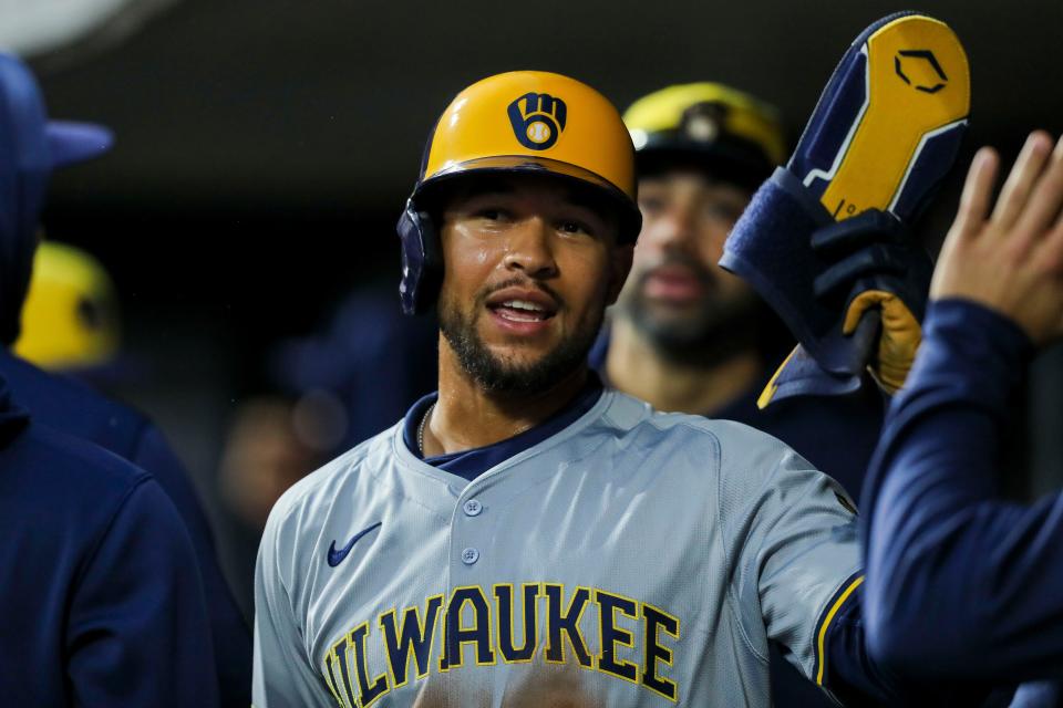 Brewers outfielder Blake Perkins high fives teammates in the dugout after scoring on a RBI single hit by Christian Yelich (not pictured) in the third inning against the Reds on Tuesday night. Perkins had three hits, three RBI and scored twice in the game.