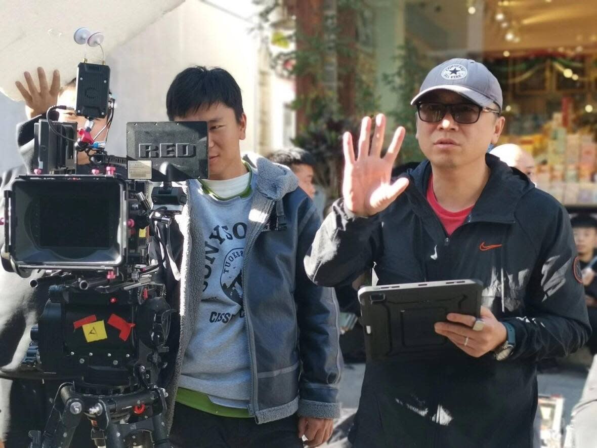 Bo Ding, right, directed his first full-feature film Dream Pawnshop on location in China. (Submitted by Bo Ding - image credit)