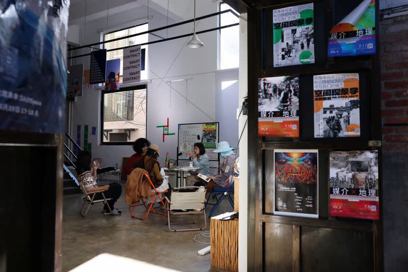 People sit and chat around a table at a youth co-working hub in Dali