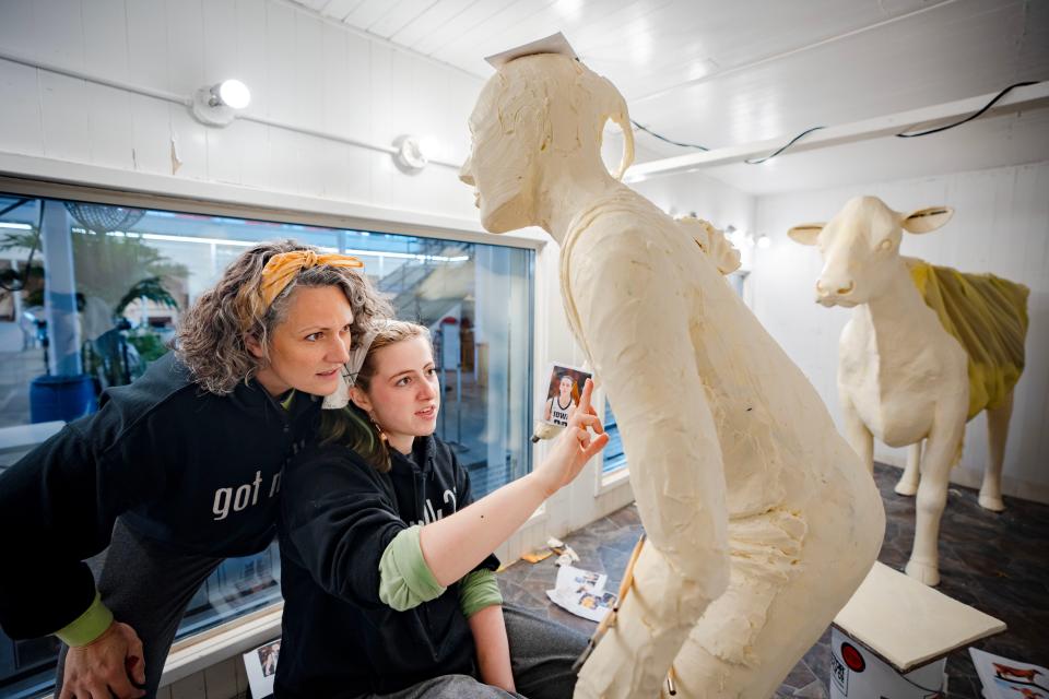 Hannah Pratt works on a butter sculpture of Caitlin Clark while her mother Sarah Pratt looks on.