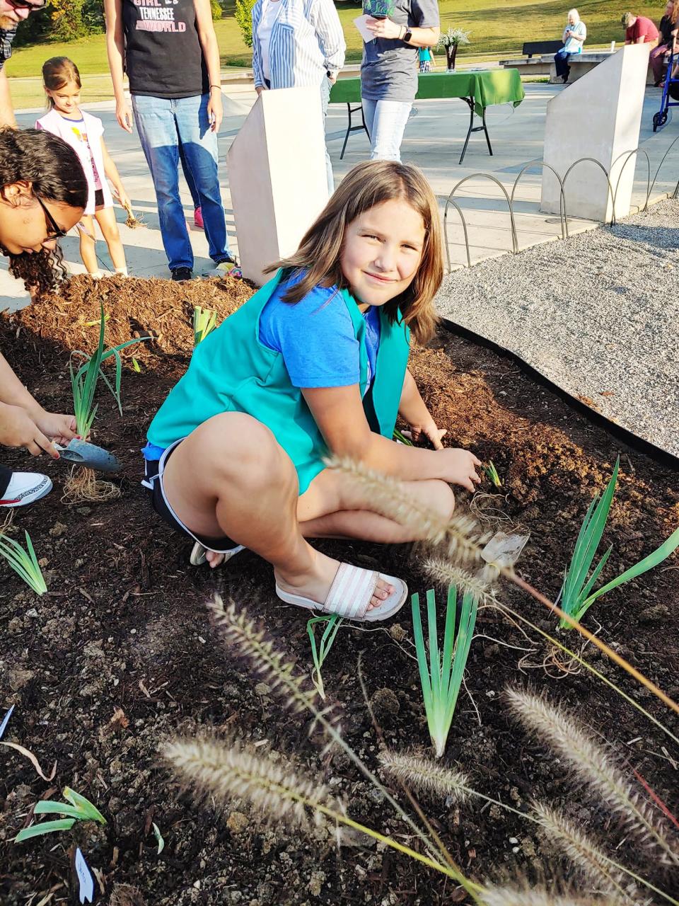Clara Fisher and friends in the Girl Scouts plant irises in memory of Shigeko Uppuluri on the International Day of Peace.