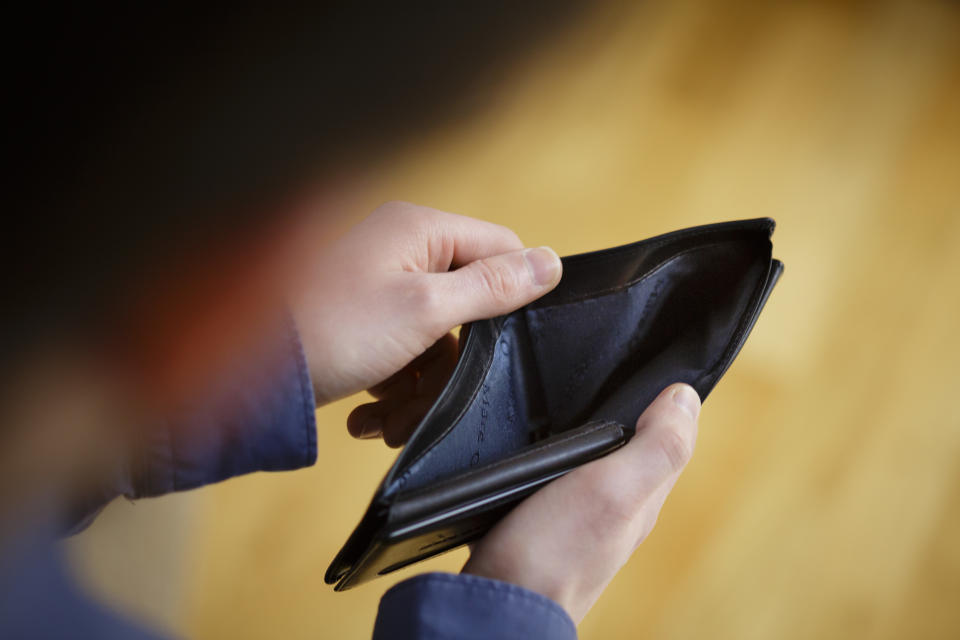 Berlin, Germany - April 05: In this photo illustration a  person opens an empty wallet on April 05, 2018 in Berlin, Germany. (Photo Illustration by Thomas Trutschel/Photothek via Getty Images)