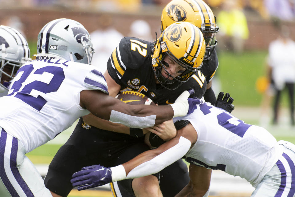 Missouri quarterback Brady Cook, center, is tackled by Kansas State linebacker Desmond Purnell, left, and safety Marques Sigle, right, during the first quarter of an NCAA college football game Saturday, Sept. 16, 2023, in Columbia, Mo. (AP Photo/L.G. Patterson)