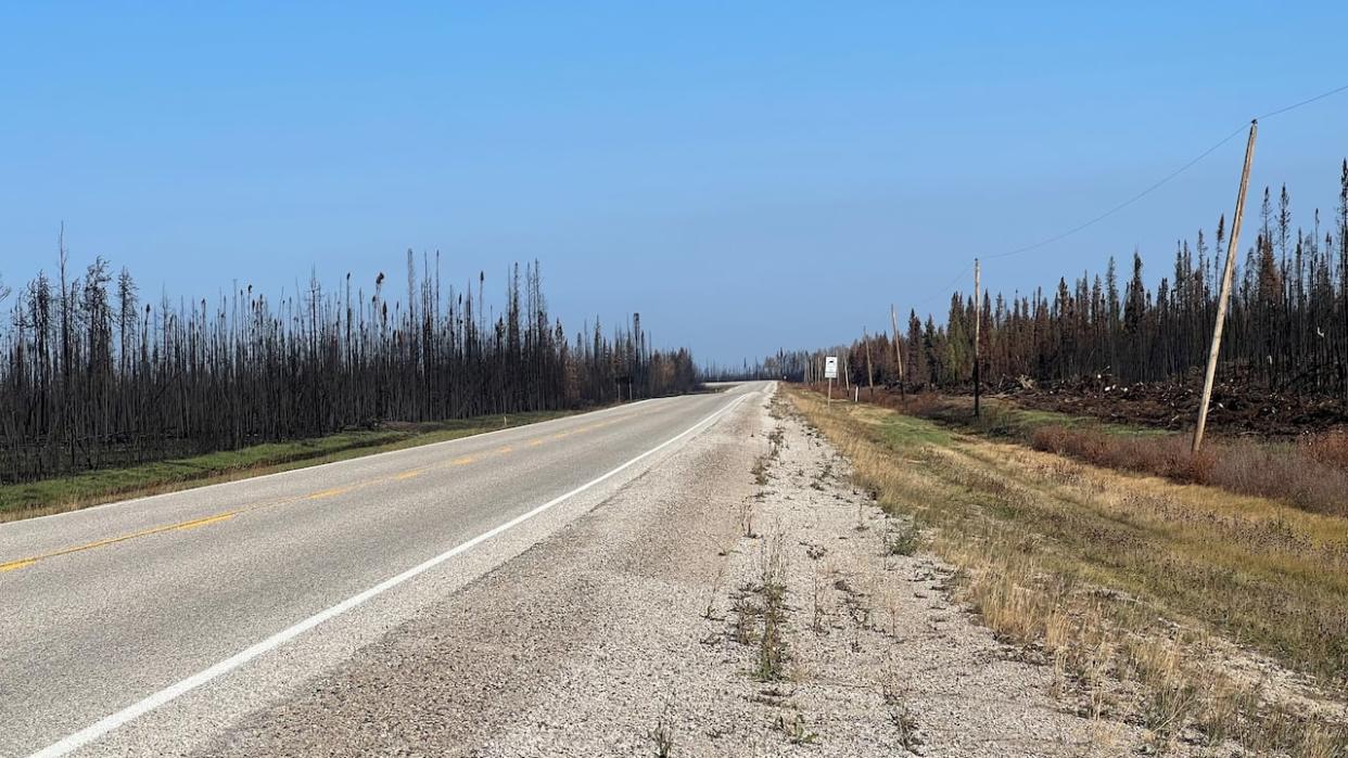 A stretch of road towards Hay River shows the burnt areas on either side of the highway. The general population was allowed to return on Saturday after a nearly five week evacuation.   (Travis Burke/CBC - image credit)