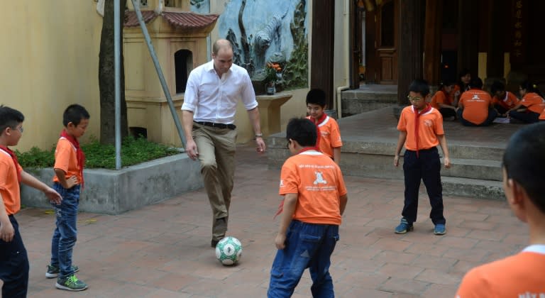 Britain's Prince William, Duke of Cambridge plays football with pupils as he visits a local primary school in the old quarters of Hanoi on November 16, 2016