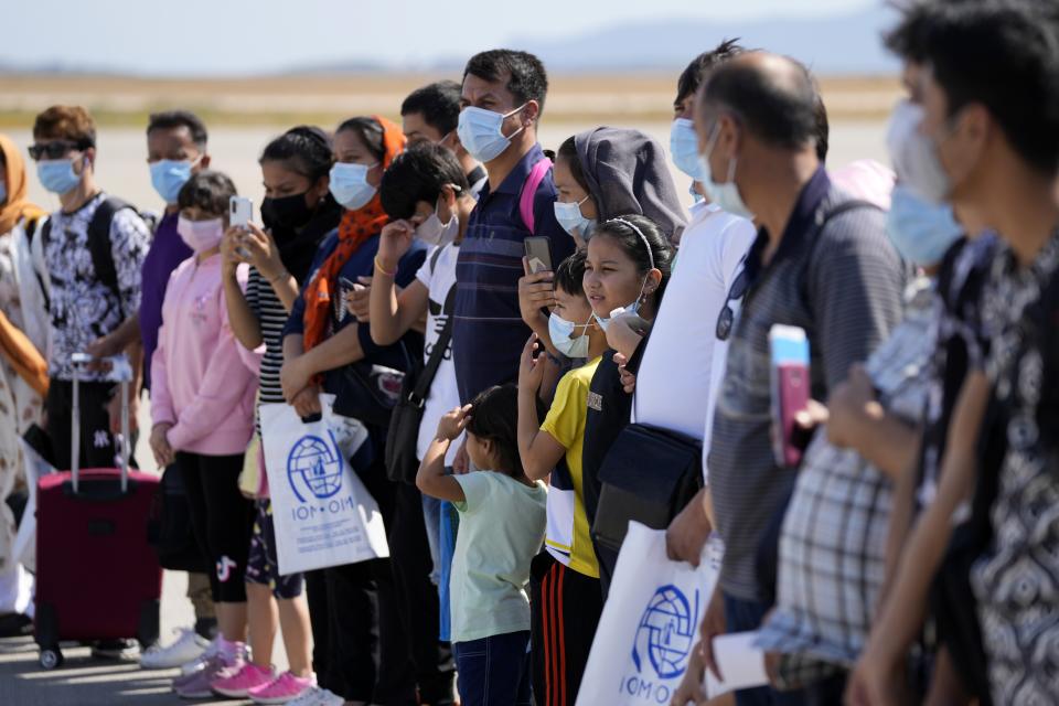 Afghan refugees wearing face masks to prevent the spread of the coronavirus, board an airplane bound for Portugal at the Eleftherios Venizelos International Airport in Athens, on Tuesday, Sept. 28, 2021. The 41 refugees from Afghanistan were relocated as part of a migrant reunification plan agreed between the two countries. (AP Photo/Thanassis Stavrakis)