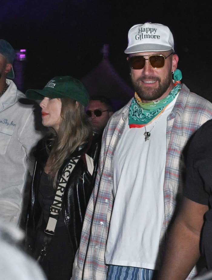 Closeup of Taylor Swift and Travis Kelce at Coachella. They're both wearing somewhat casual clothes and baseball caps