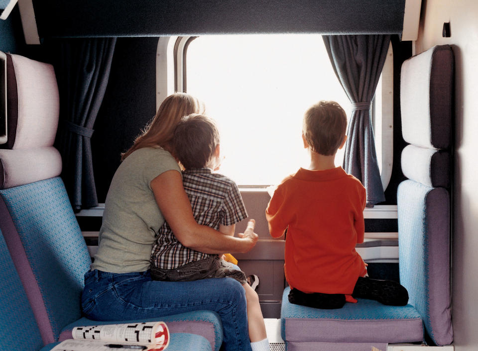 This undated photo provided by Amtrak shows passengers looking out the window on the California Zephyr, a train that runs between Emeryville, Calif., and Reno, Nev., a 236-mile journey that offers scenic views as well as history. It crosses the Sierra Nevada mountain range and follows the same course as the historic Transcontinental Railroad, a 19th century engineering feat that bolstered the nation’s western expansion. The Zephyr’s ultimate destination is Chicago, a 51-hour trip from Emeryville.(AP Photo/Amtrak)