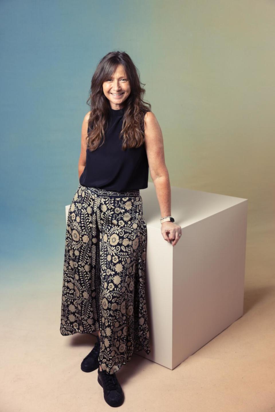 Victoria Gregory stands leaning against a cube.