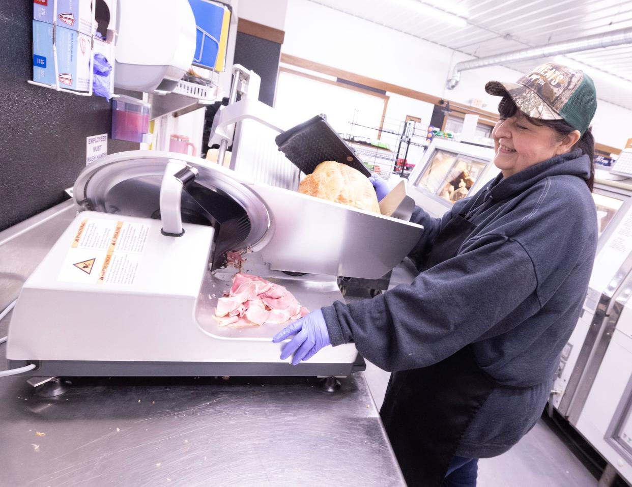 3D Meats worker Mary Hair slices some deluxe ham Tuesday at the Dalton store. The meat shop is opening a second location in Massillon later this year.