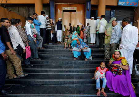 People wait for a bank to open to withdraw and deposit their money, after the scrapping of high denomination 500 and 1,000 Indian rupees currency notes, in Ahmedabad, India, December 5, 2016. REUTERS/Amit Dave/File photo