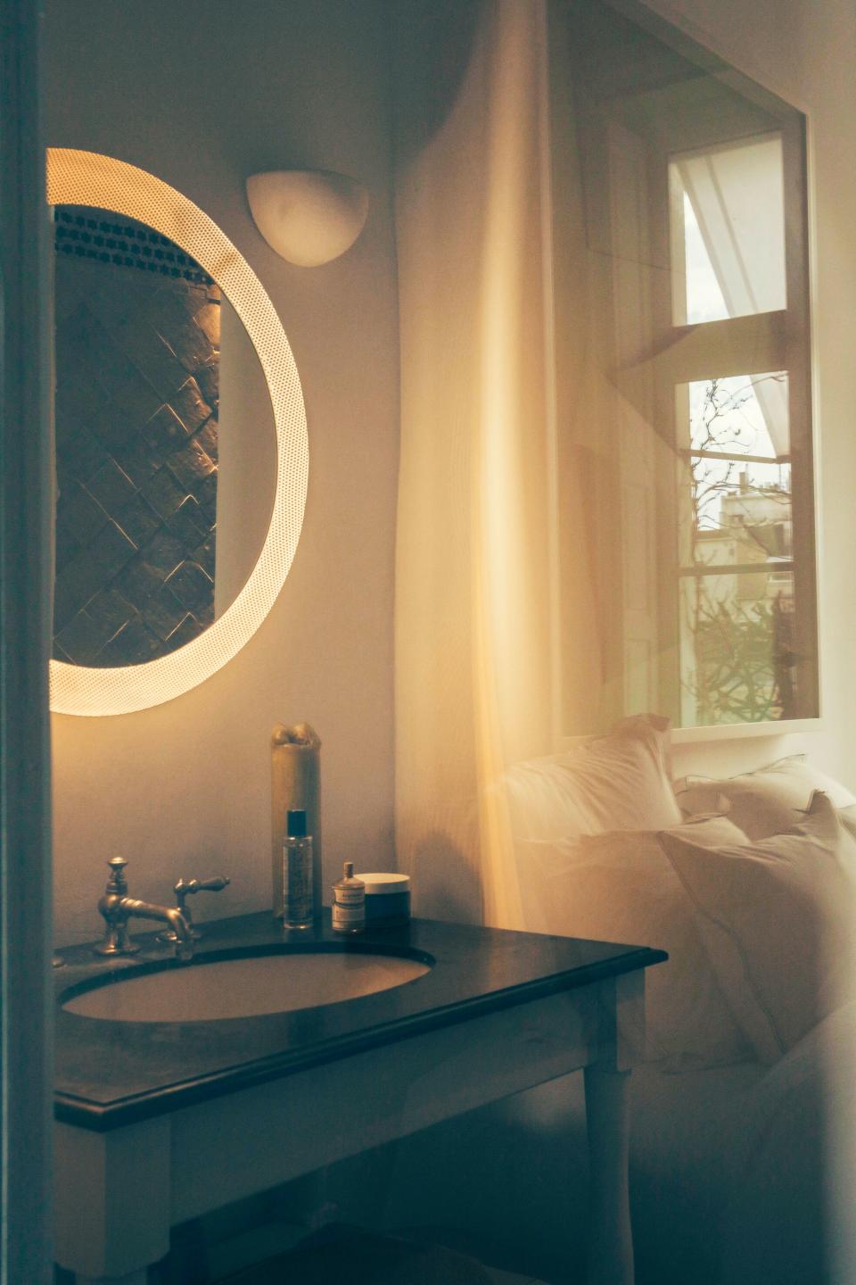 A round backlit mirror, sourced at a local gallery, makes a statement in the bathroom, which floods with sunlight from the south-facing windows.