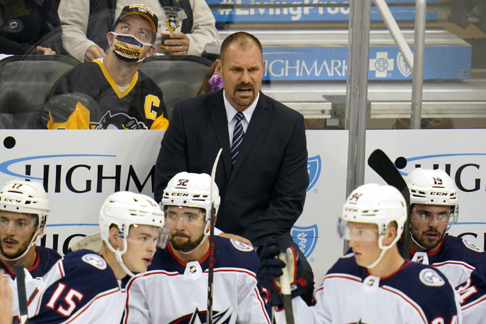 Columbus Blue Jackets head coach Brad Larsen stands behind his bench during the first period of an NHL exhibition hockey game against the Pittsburgh Penguins in Pittsburgh, Monday, Sept. 27, 2021. (AP Photo/Gene J. Puskar)