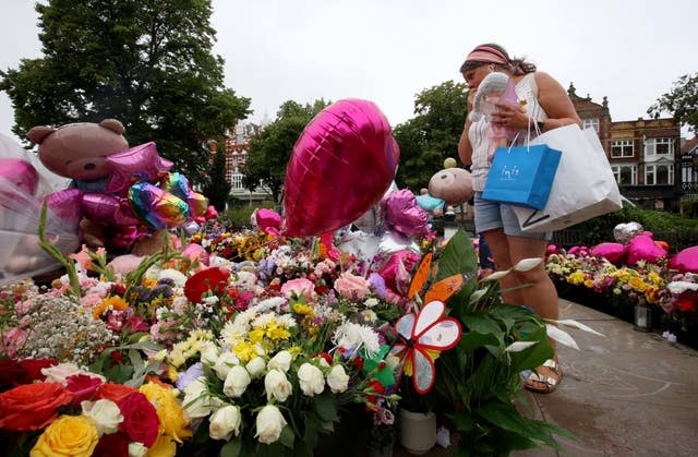 Members of the public look at floral tributes