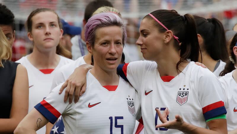 In this July 7, 2019, file photo, United States' Megan Rapinoe, left, talks to her teammate Alex Morgan, right, after winning the Women's World Cup final soccer match against Netherlands at the Stade de Lyon in Decines, outside Lyon, France.
