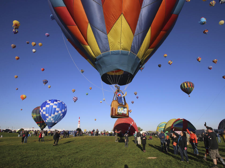 A balloonist lifts-off at the Albuquerque International Balloon Fiesta in Albuquerque, N.M., Sunday, Oct. 6, 2019. (Jerry Larson/Waco Tribune-Herald via AP)