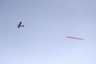 A plane with a 'Say No To Super League' banner flies over Elland Road, as a protest against Liverpool's decision to be included amongst the clubs attempting to form a new European Super League, in Leeds, England, Monday, April 19, 2021. Reaction to the proposals from 12 clubs to rip up European soccer by forming a breakaway Super League has ranged from anger and condemnation to humor and sarcasm. (Zac Goodwin/PA via AP)