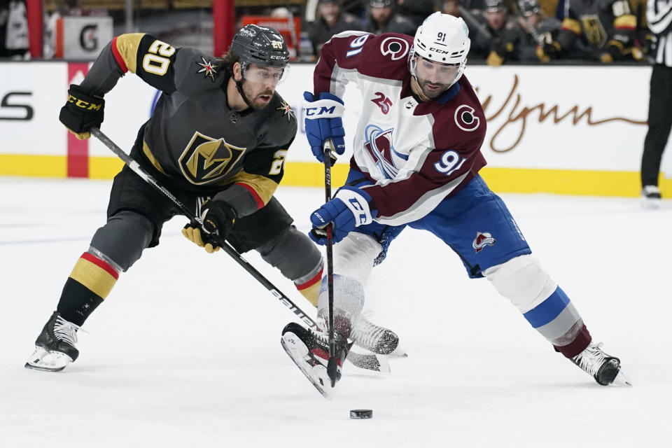 Colorado Avalanche center Nazem Kadri (91) skates around Vegas Golden Knights center Chandler Stephenson (20) during the third period of an NHL hockey game Monday, May 10, 2021, in Las Vegas. (AP Photo/John Locher)