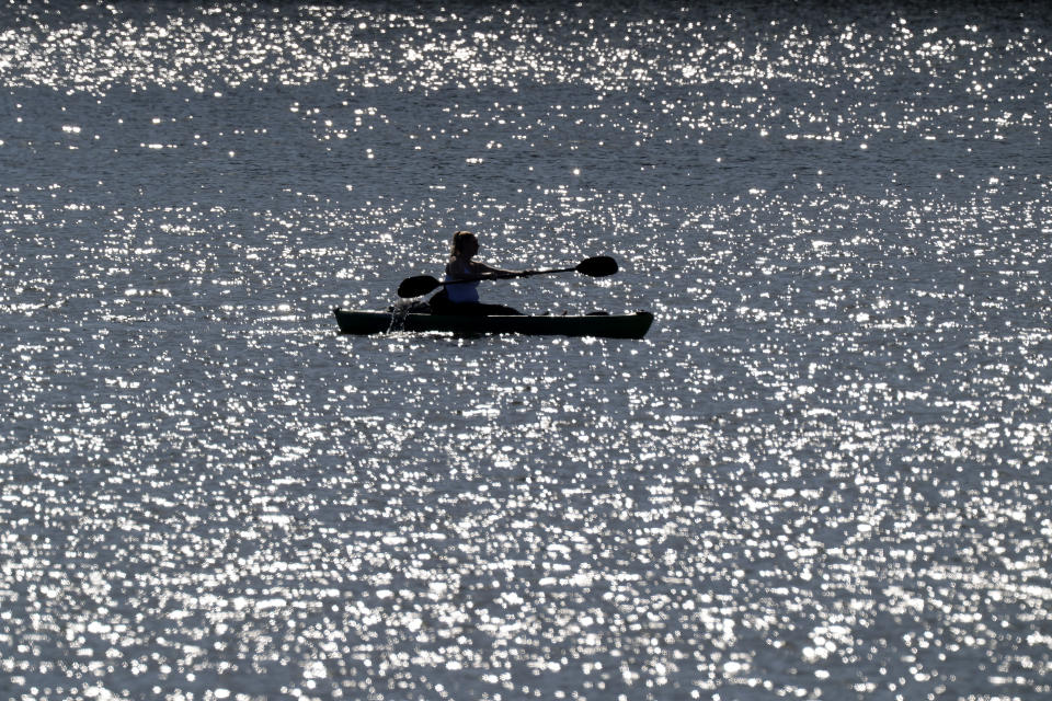 A woman takes advantage of unseasonably warm weather, Sunday, Feb. 25, 2024, to kayak on Smithville Lake near Paradise, Mo. With highs in the mid 70s, parts of the midwest are experiencing temperatures nearly 30 degrees hotter than average. (AP Photo/Charlie Riedel)