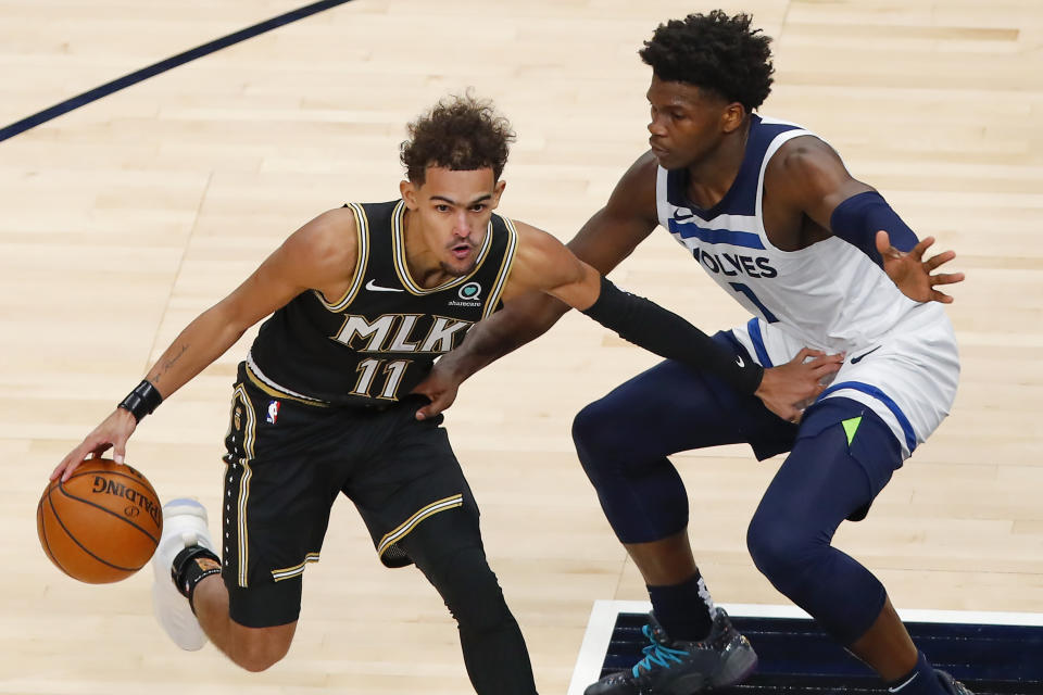 Atlanta Hawks guard Trae Young (11) battles Minnesota Timberwolves guard Anthony Edwards (1) in the second half of an NBA basketball game on Monday, Jan. 18, 2021, in Atlanta. (AP Photo/Todd Kirkland)