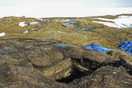 This May 3, 2009, photo taken in Point Hope, Alaska, provided by the Alaska Native Tribal Health Consortium, shows the entrance to an ice cellar, a type of underground food dug into the permafrost to provide natural refrigeration used for generations in far-north communities. Naturally cooled underground ice cellars, used in Alaska Native communities for generations, are becoming increasingly unreliable as a warming climate and other factors touch multiple facets of life in the far north. (Mike Brubaker/Alaska Native Tribal Health Consortium via AP) (Mike Brubaker/Alaska Native Tribal Health Consortium via AP)