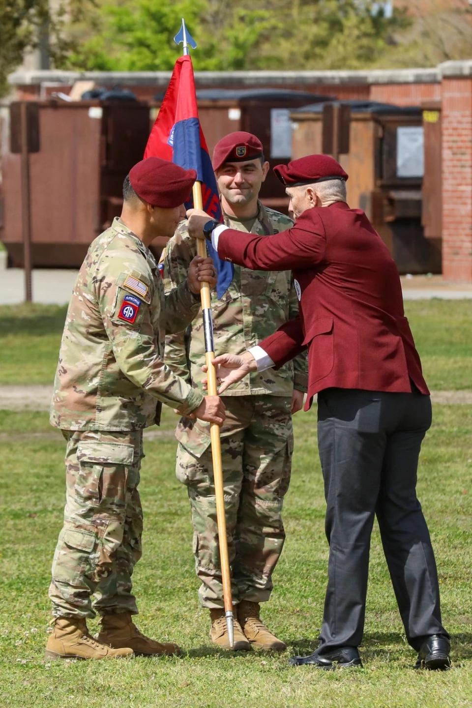 Retired Command Sgt. Maj. William J. Gainey passes the guidon to Lt. Col. Leif Thaxton, commander of Headquarters and Headquarters Battalion, 82nd Airborne Division during a March 29, 2023, uncasing ceremony of Gainey Company on Fort Bragg.