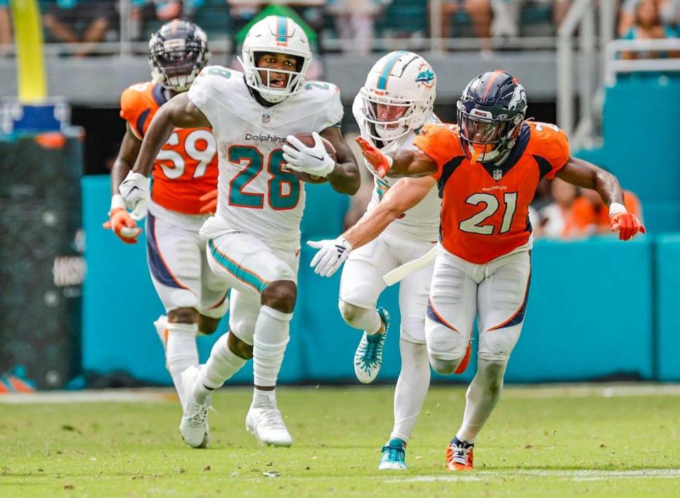 Miami Dolphins running back De’Von Achane (28) gets ahead of the tackle attempt by Denver Broncos cornerback Essang Bassey (21) to score a touchdown in the fourth quarter at Hard Rock Stadium in Miami Gardens on Sunday, September 24, 2023. Al Diaz/adiaz@miamiherald.com