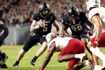 North Carolina State quarterback Brennan Armstrong (5) runs the ball behind the block of Demarcus Jones II (28) during the first half of the team's NCAA college football game against Louisville in Raleigh, N.C., Friday, Sept. 29, 2023. (AP Photo/Karl B DeBlaker)