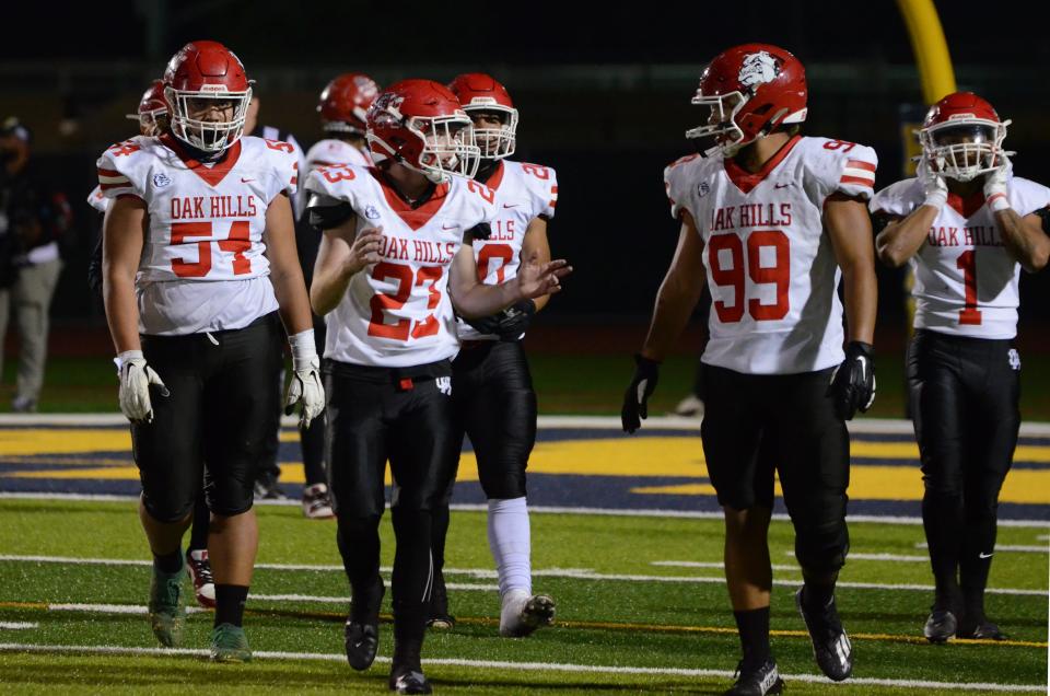 Oak Hills' Peyton Metzger, left, speaks with Charles King after a play during the second quarter of the CIF-Southern Section Division 3 quarterfinals against Warren on Friday, Nov. 10, 2023.