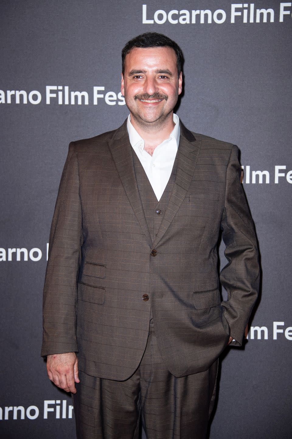 david krumholtz wearing a brown suit and smiling