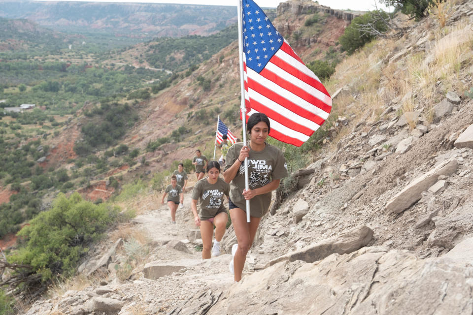 A group of wrestlers run up the trail Saturday morning at the Iwo Jima Flag Run at Palo Duro Canyon.