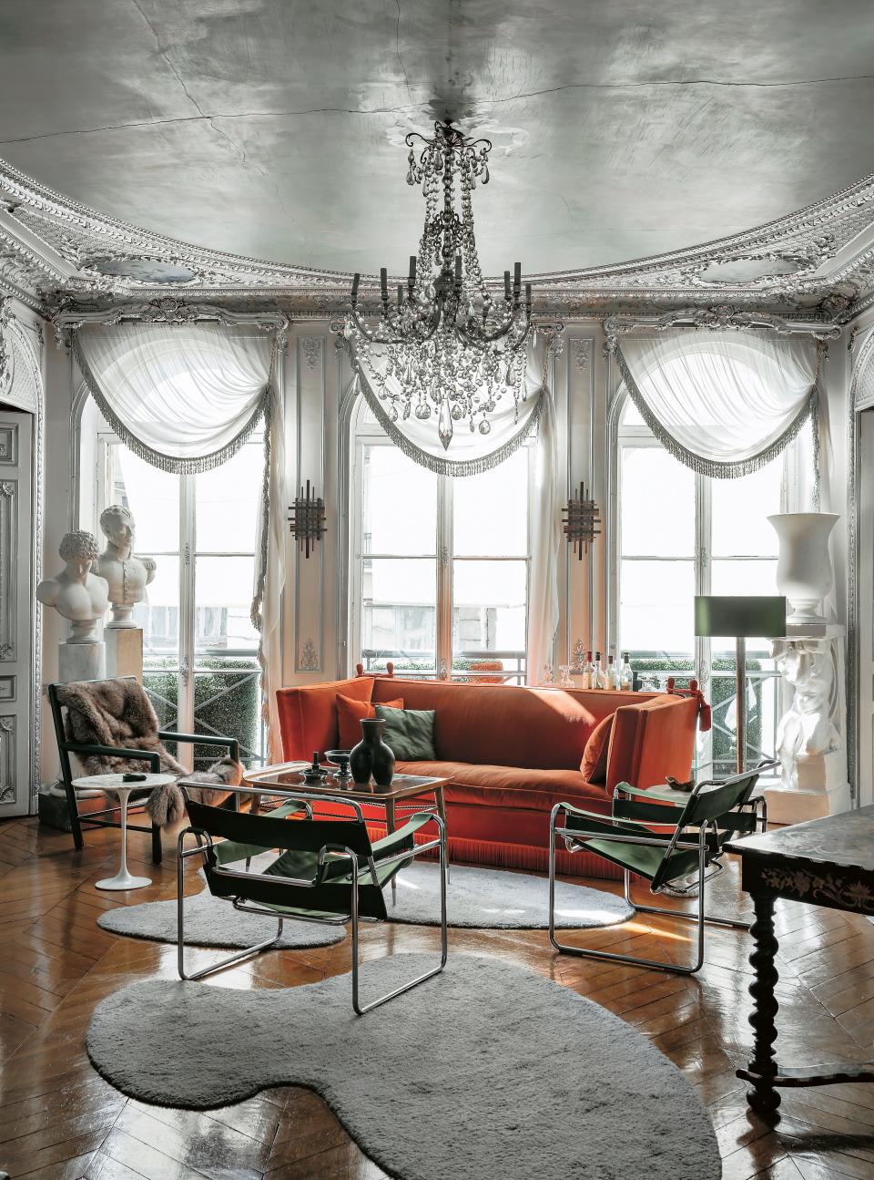 The Parisian apartment of Michael Coorengel and Jean-Pierre Calvagrac blends classical details and a modern aesthetic. In the living room, a fur-draped Mallet-Stevens chair sits beside a silk velvet sofa by Jansen and Breuer Wassily chairs reupholstered in green duchess satin.