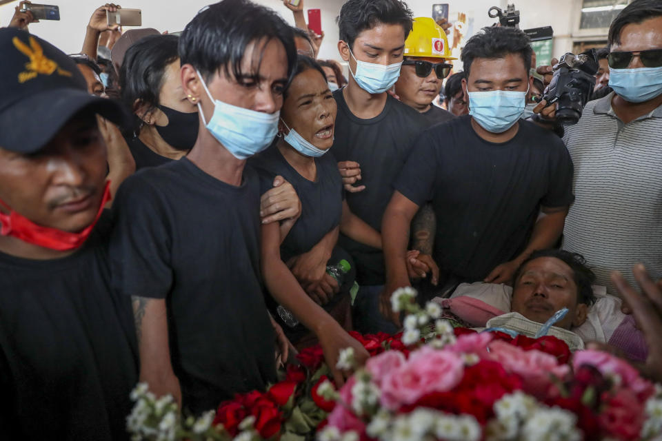 Thida Hnin, third from left, cries over the body of her husband Thet Naing Win during his funeral at Kyarnikan cemetery in Mandalay, Myanmar, Tuesday, Feb. 23, 2021. Thet Naing Win was shot and killed by Myanmar security forces during an anti-coup protest on Saturday, Feb. 20. (AP Photo)