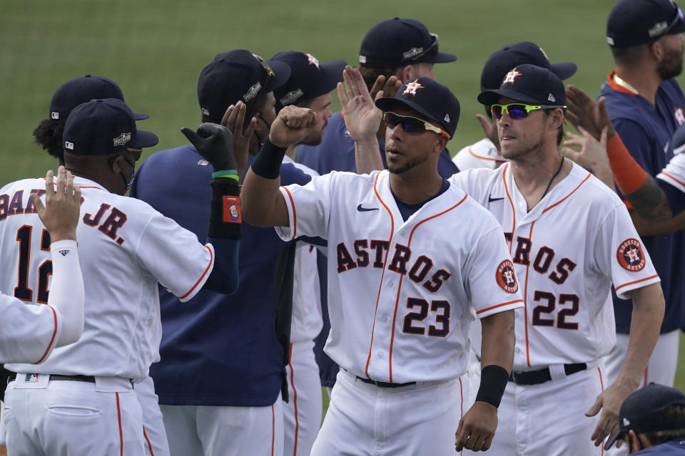 Houston Astros manager Dusty Baker Jr., left, celebrates with Michael Brantley (23), Josh Reddick (22) and others after the Astros defeated the Oakland Athletics in Game 4 of a baseball American League Division Series in Los Angeles, Thursday, Oct. 8, 2020. (AP Photo/Ashley Landis)