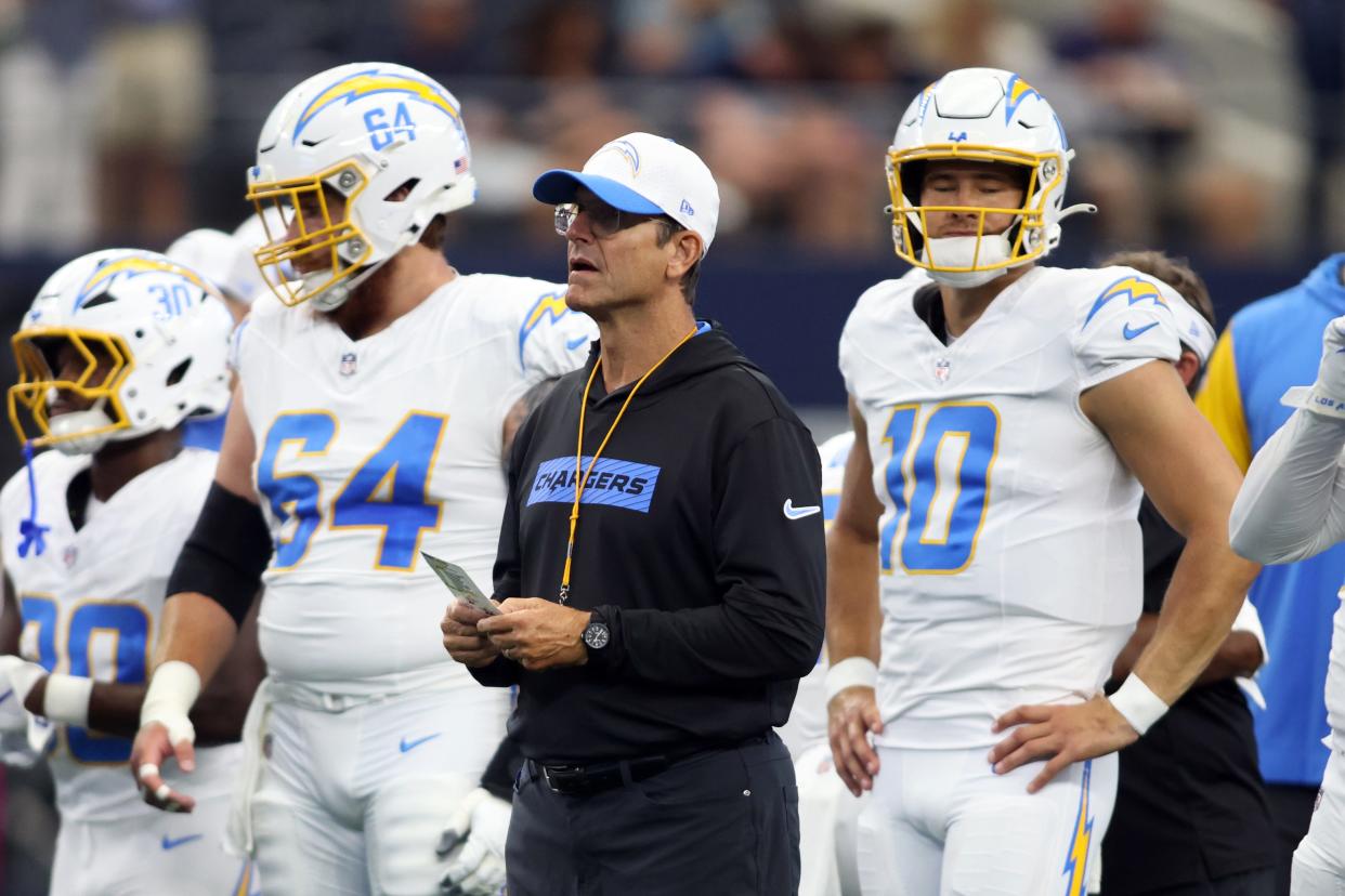 Los Angeles Chargers head coach Jim Harbaugh stands alongside Justin Herbert before the preseason game against the Dallas Cowboys.