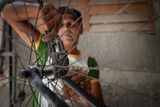 Cuban Felix Guirola fixes a bicycle wheel in his workshop in Havana on June 29. Guirola hopes that the Guinness World Records will officially recognize his latest giant bicycle, which measures 5.6 meters in height, as the biggest ever ridden