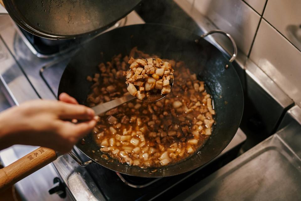 Pork belly is cooked in a kitchen.